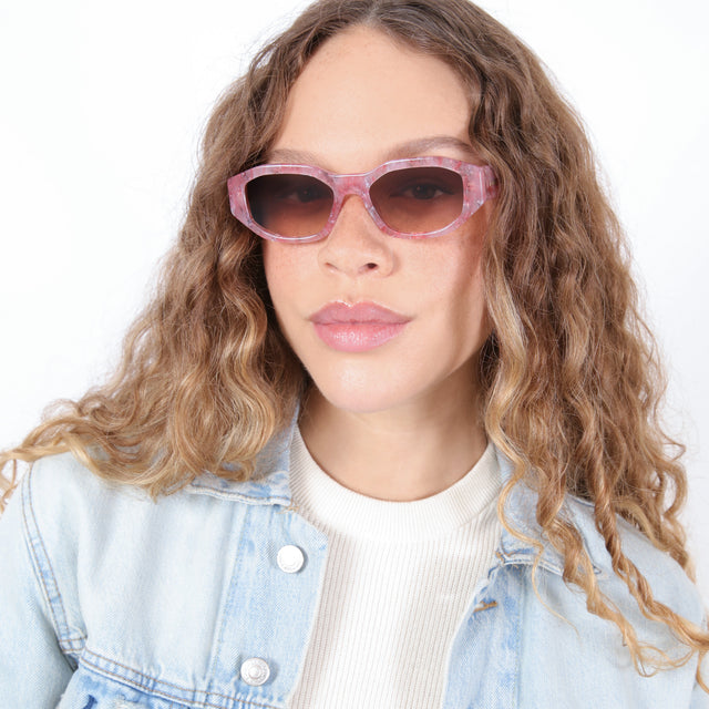 Brunette model with ombré, natural curls wearing Cassette Sunglasses Rose Quartz with Brown Flat Gradient