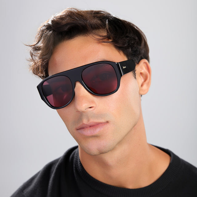 Man in a black shirt wearing Colorado Sunglasses Black with Plum See Through
