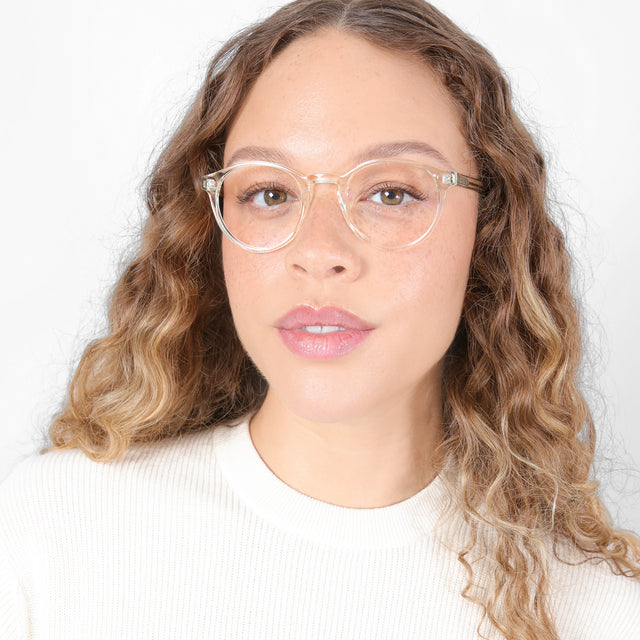 Brunette model with ombré, natural curls wearing Como Optical Champagne Optical