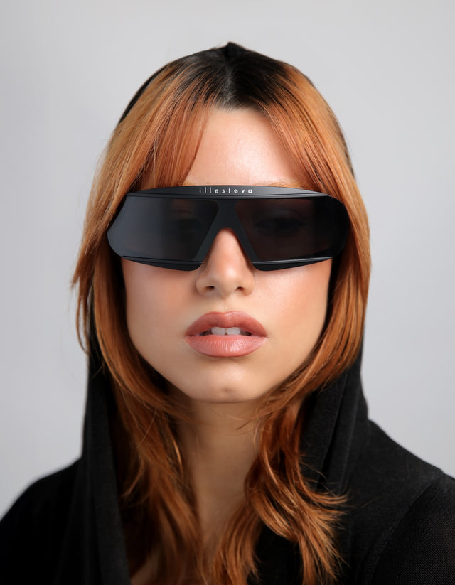 Person wearing futuristic Courchevel black sunglasses in a hoodie