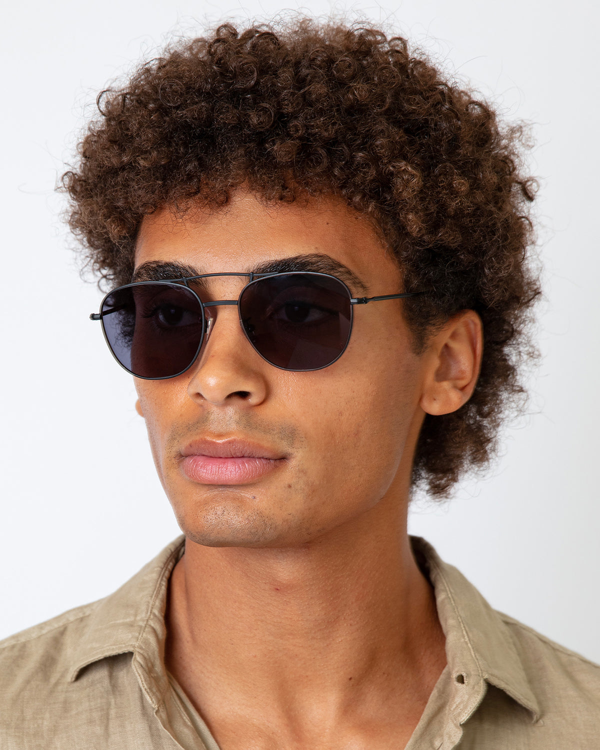 Man wearing Cyprus Sunglasses in Matte Black with Grey Flat lenses, Model with afro-curly hair