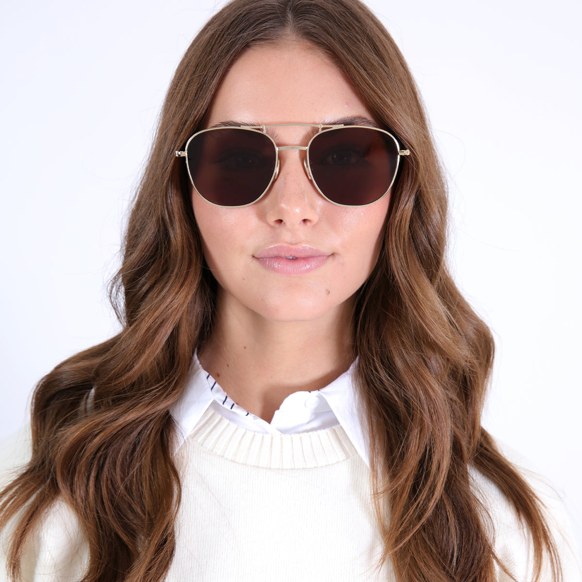 Woman wearing Cyprus Sunglasses in Gold with Brown Flat lenses, Brunette model with loose curls