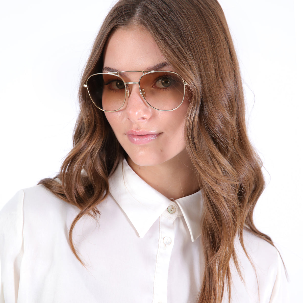 Woman wearing Cyprus Sunglasses in Gold with Taupe Flat Gradient lenses, Brunette model with loose curls