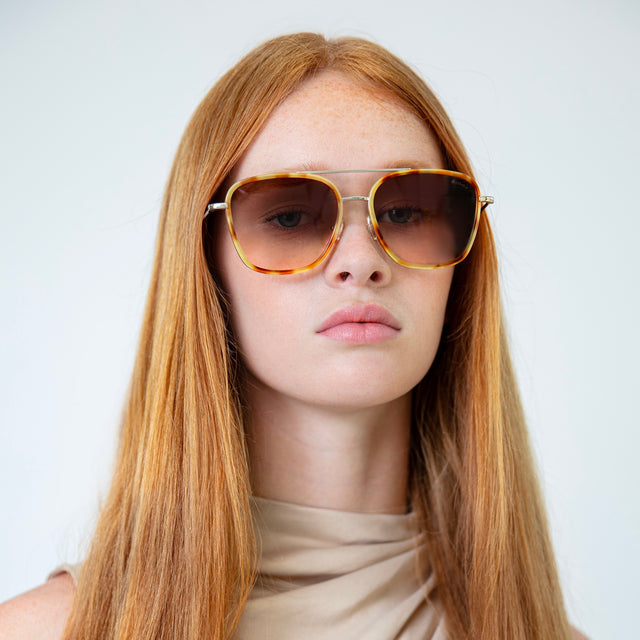 Model with straight red hair wearing Delos Ace Sunglasses Amber/Gold with Brown Flat Gradient