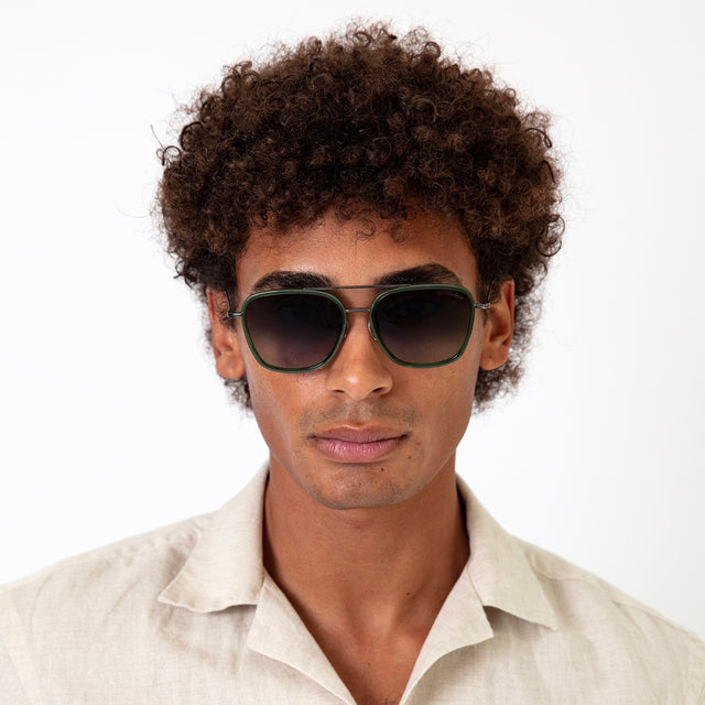 Model with afro-curly hair wearing Delos Ace Sunglasses Cactus/Gunmetal with Grey Flat Gradient