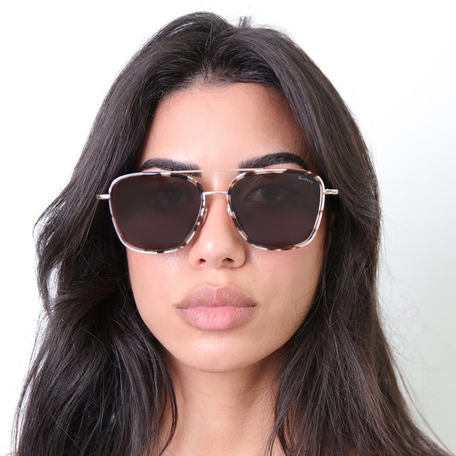 Brunette with wavy hair wearing Delos Ace Sunglasses White Tortoise/Rose Gold with Grey Flat