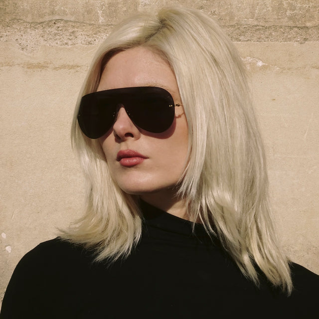 Woman in Paris leaning against a wall wearing Douglas Mask Sunglasses Grey with Grey