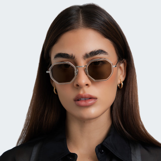 Close up of the woman in a black satin blouse wearing Dylan Tate Sunglasses Champagne Silver with Brown Flat
