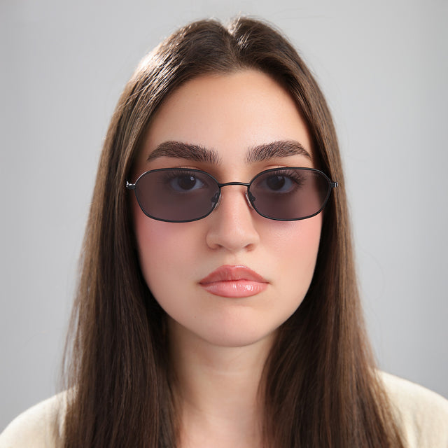 Brunette model in a cream blouse wearing East Houston Sunglasses Matte Black with Grey Flat