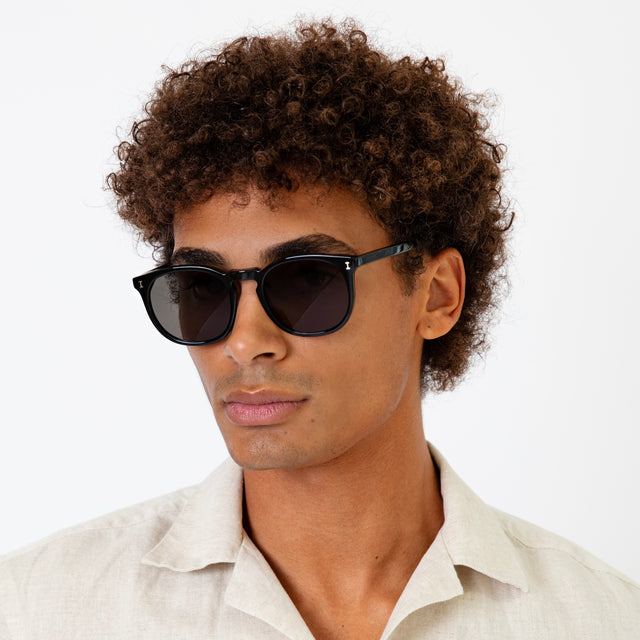 Model with afro-curly hair wearing Eldridge 56 Sunglasses Black with Grey Flat