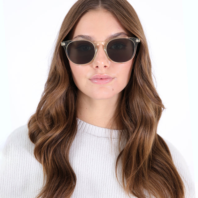 Brunette model with loose curls wearing Eldridge 56 Sunglasses Champagne with Olive Flat