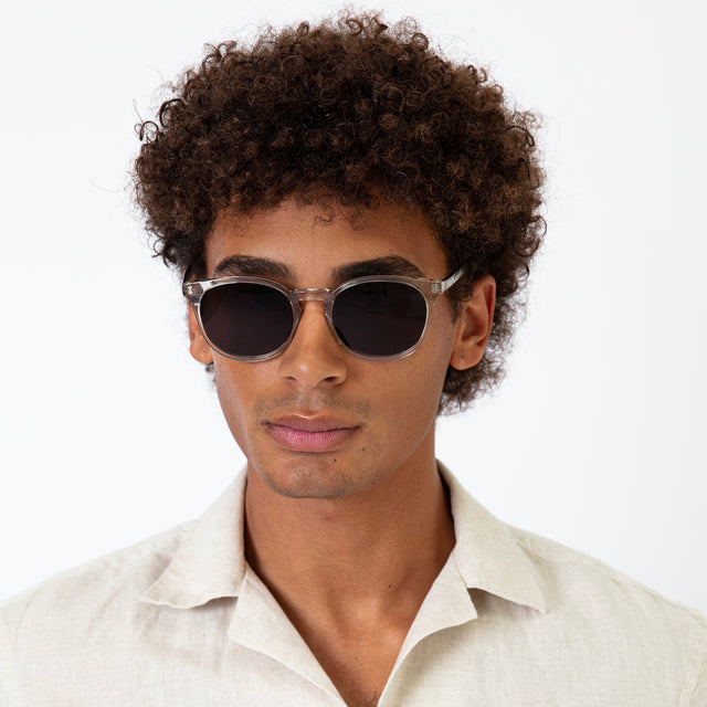 Model with afro-curly hair wearing Eldridge 56 Sunglasses Cool Grey with Grey Flat