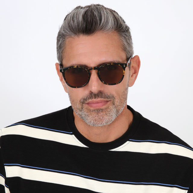 Model with salt and pepper hair and beard wearing Eldridge 56 Sunglasses Flame with Brown Flat