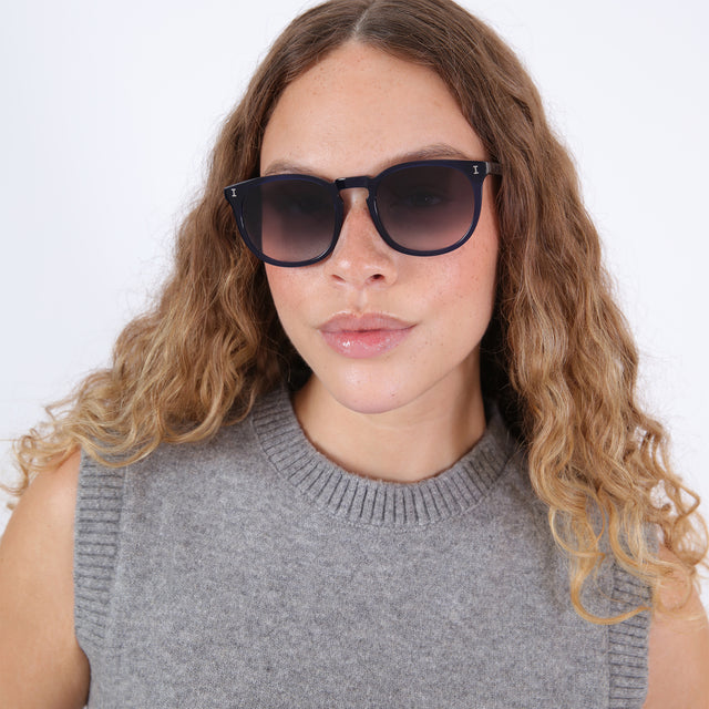 Brunette model with ombré natural curls wearing Eldridge 56 Sunglasses Navy with Grey Flat Gradient