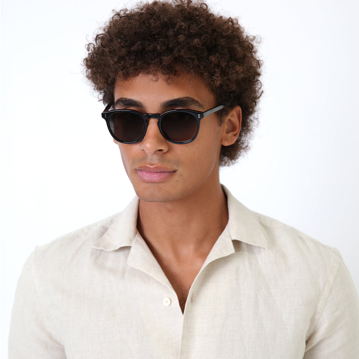 Man wearing Eldridge Sunglasses in Black with Grey Flat lenses, Model with natural afro-curly hair
