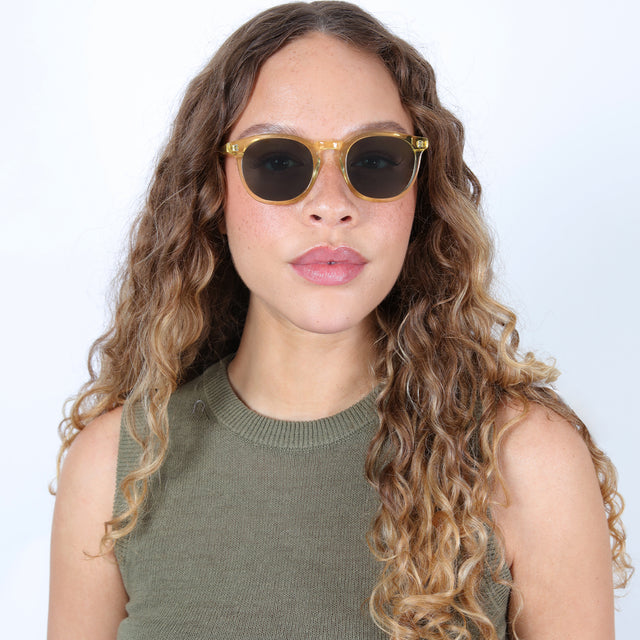 Brunette model with ombre, natural curls wearing Eldridge Sunglasses Clear Blond with Olive Flat