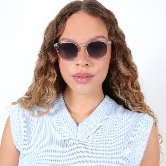 Brunette model with ombre, natural curls wearing Eldridge Sunglasses Clear with Grey Flat Gradient