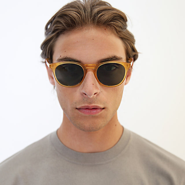 Model with light brown hair combed back wearing Eldridge Light Sunglasses Honey Gold with Olive Flat