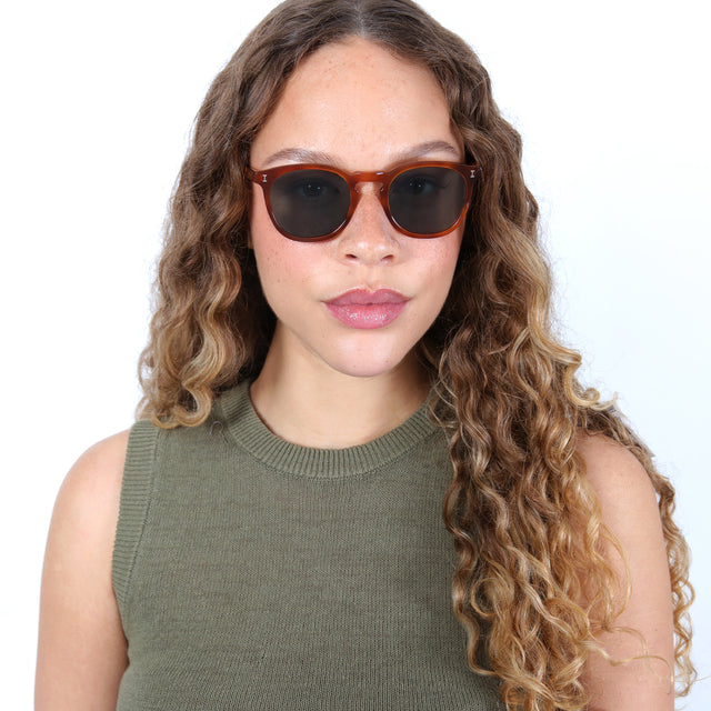 Brunette model with ombre, natural curls wearing Eldridge Sunglasses Red Havana with Olive Flat