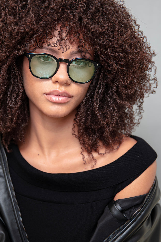 A girl with curly hair wearing sunglasses