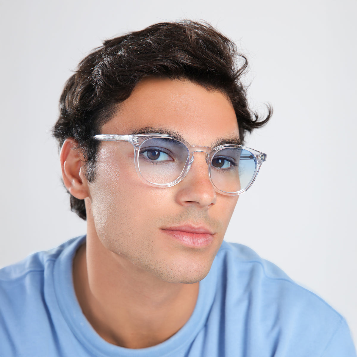 Man wearing Eldridge Sunglasses in Clear with Blue Flat Gradient See Through lenses, side profile, Man in a blue shirt