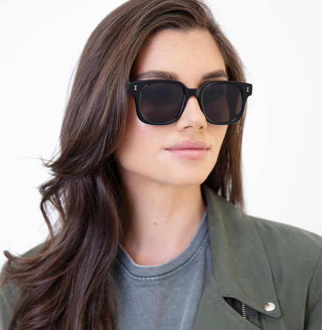 Brunette model with wavy hair wearing Ellison Sunglasses Black with Grey Flat