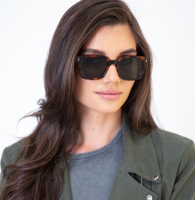 Brunette model with straight hair wearing Ellison Sunglasses Havana with Olive Flat