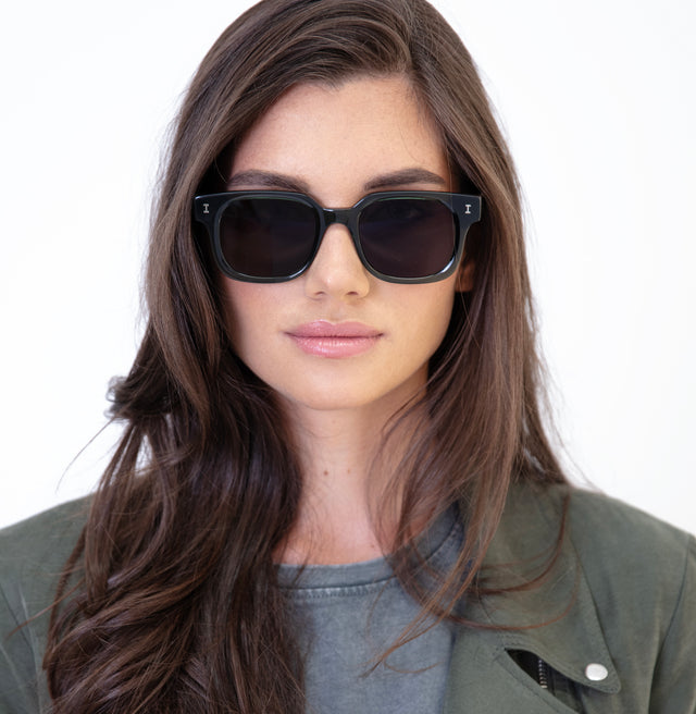 Brunette model with straight hair wearing Ellison Sunglasses Pine with Grey Flat