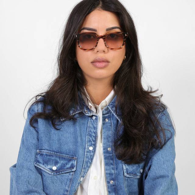 Brunette model in a denim jacket wearing Ellison Sunglasses Sand Dune with Brown Flat Gradient