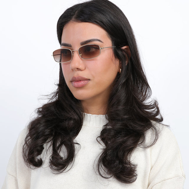 Brunette model with loose curls looking right wearing Flushing Sunglasses Rose Gold with Brown Flat Gradient