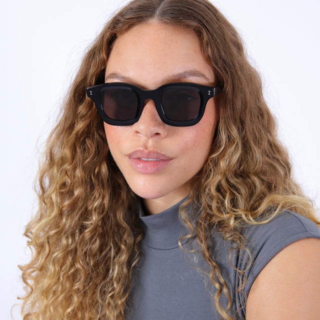 Brunette model with wavy hair wearing George Sunglasses Black with Grey Flat