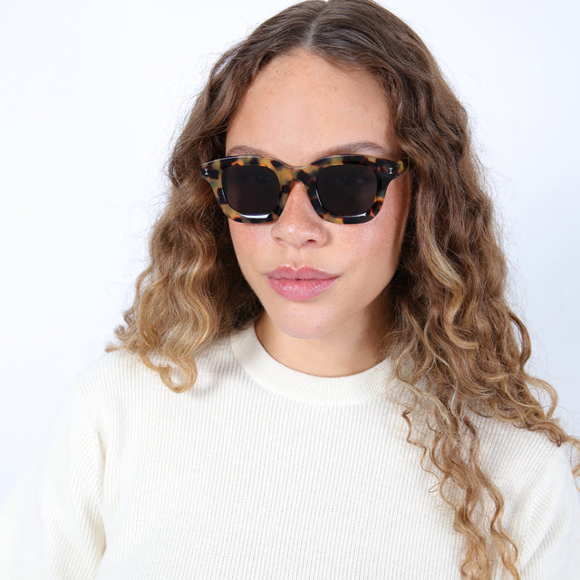 Brunette model with ombre curls wearing George Sunglasses Tortoise with Grey Flat