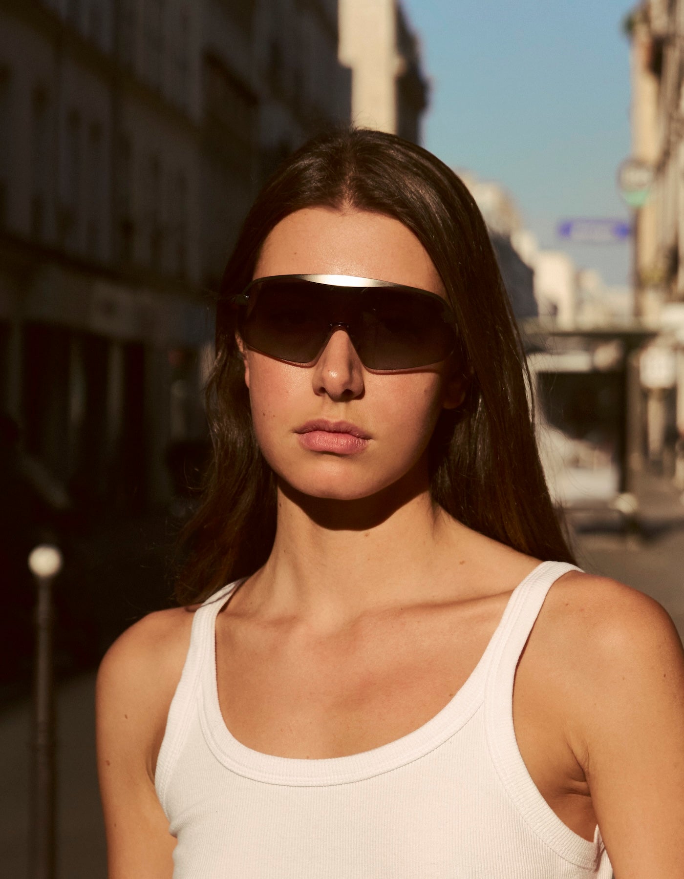Woman wearing Hopper sunglasses and a white tank top in Paris