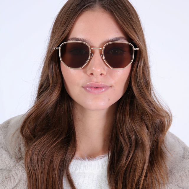Brunette model in a soft, furry jacket wearing Hunter Ace Sunglasses Champagne/Gold with Brown