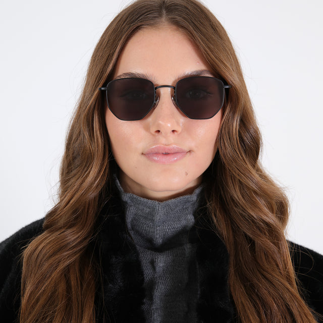 Brunette with loose curls wearing Hunter Sunglasses All Matte Black with Grey