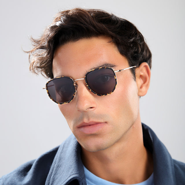 Man in a navy jacket wearing Hunter Ace Sunglasses Flame/Gold with Grey