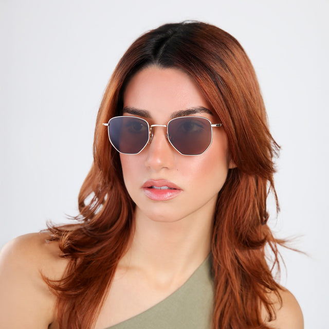 Another angle of woman with red hair in an olive blouse wearing Hunter Sunglasses Gold with Brown