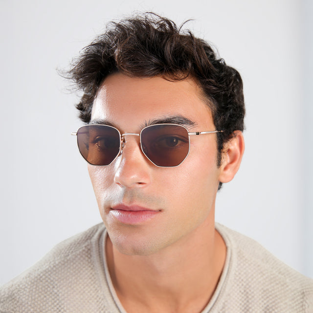 Man with brown hair in a beige waffled sweatshirt wearing Hunter Sunglasses Gold with Brown