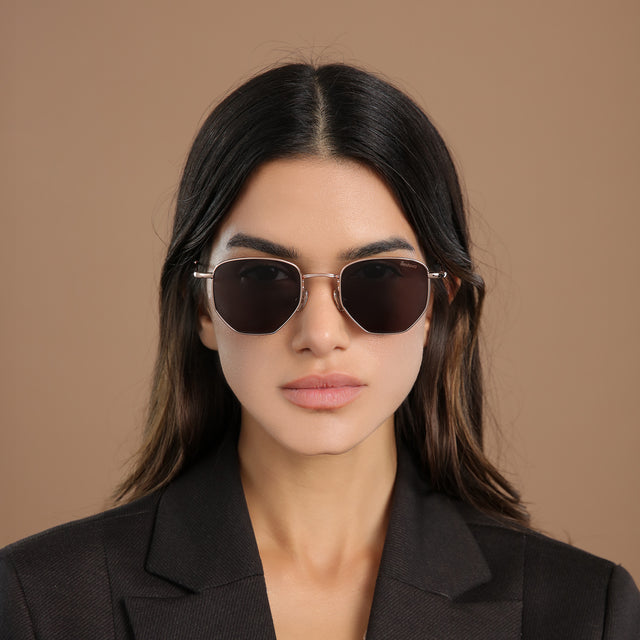 Brunette model in a black blazer wearing Hunter Sunglasses Rose Gold with Grey