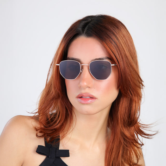 Another angle of woman with red hair in a black blouse wearing Hunter Sunglasses Rose Gold with Grey