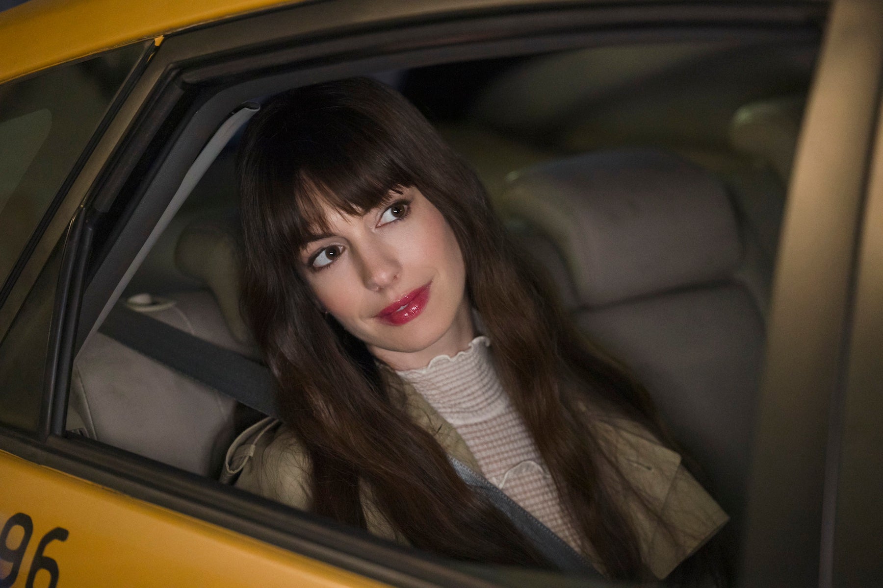 Still from 'The Idea of You' featuring Anne Hathaway looking out of the window of a yellow taxi cab