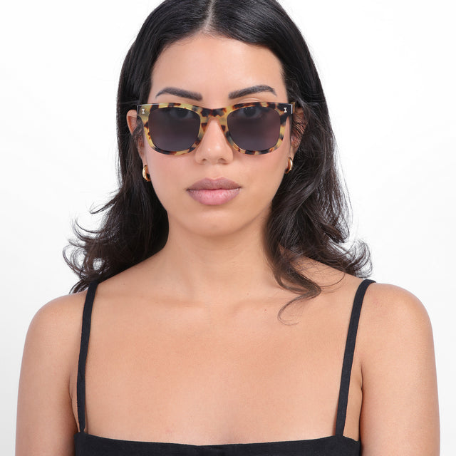 Brunette model with loose curls wearing James Sunglasses Tortoise with Grey