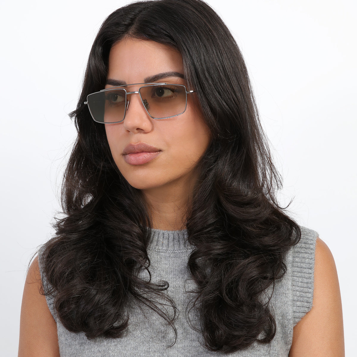 Woman wearing Jane Sunglasses in Gunmetal with Taupe Gradient lenses, Brunette model with loose curls looking right