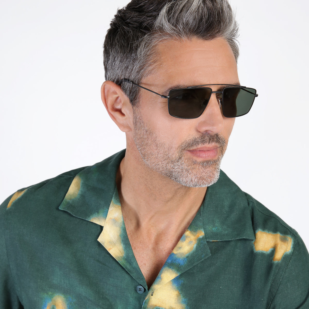 Man wearing Jane Sunglasses in Matte Black with Olive lenses, Model with salt and pepper beard looking left