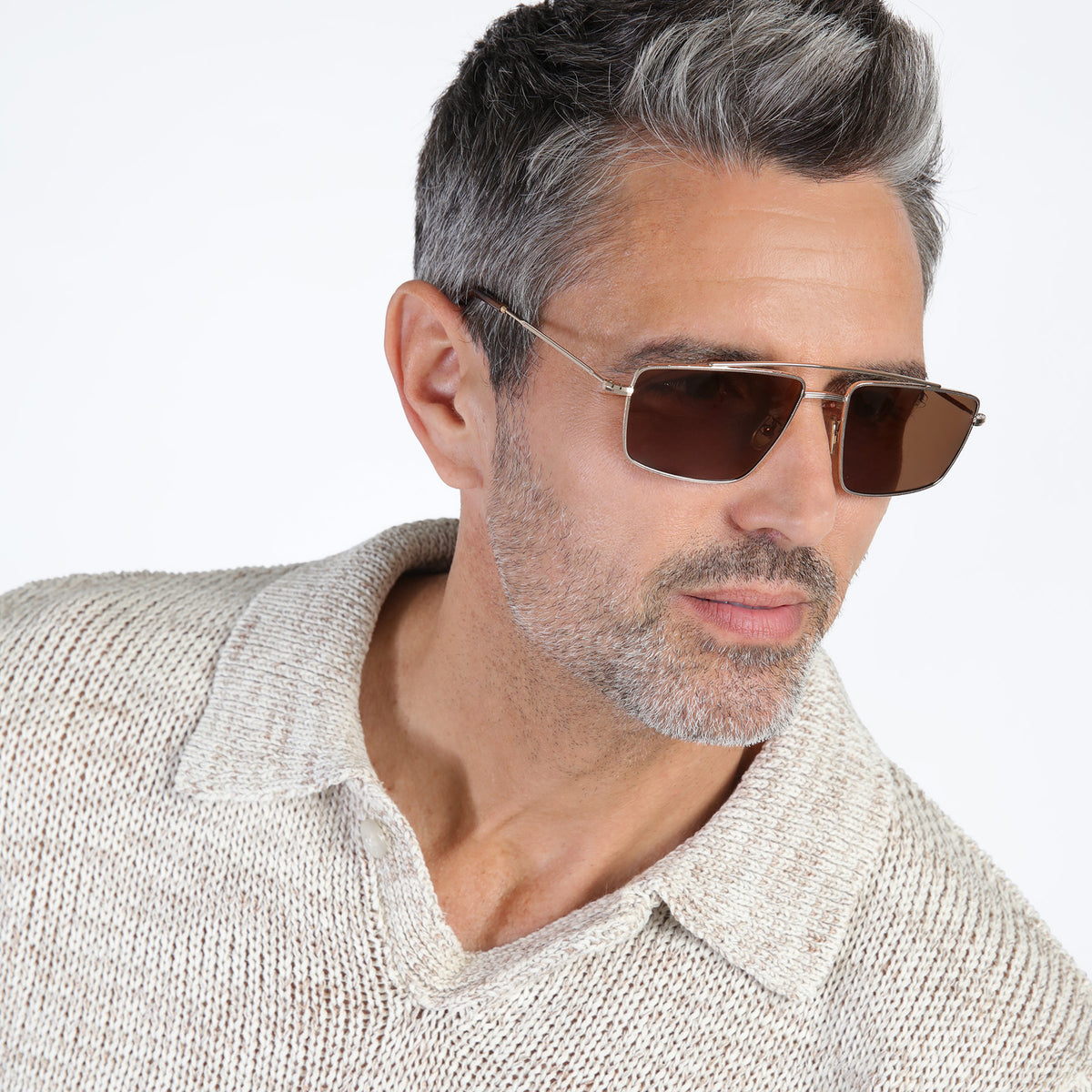 Man wearing Jane Sunglasses in Rose Gold with Brown lenses, Model with salt and pepper beard looking left