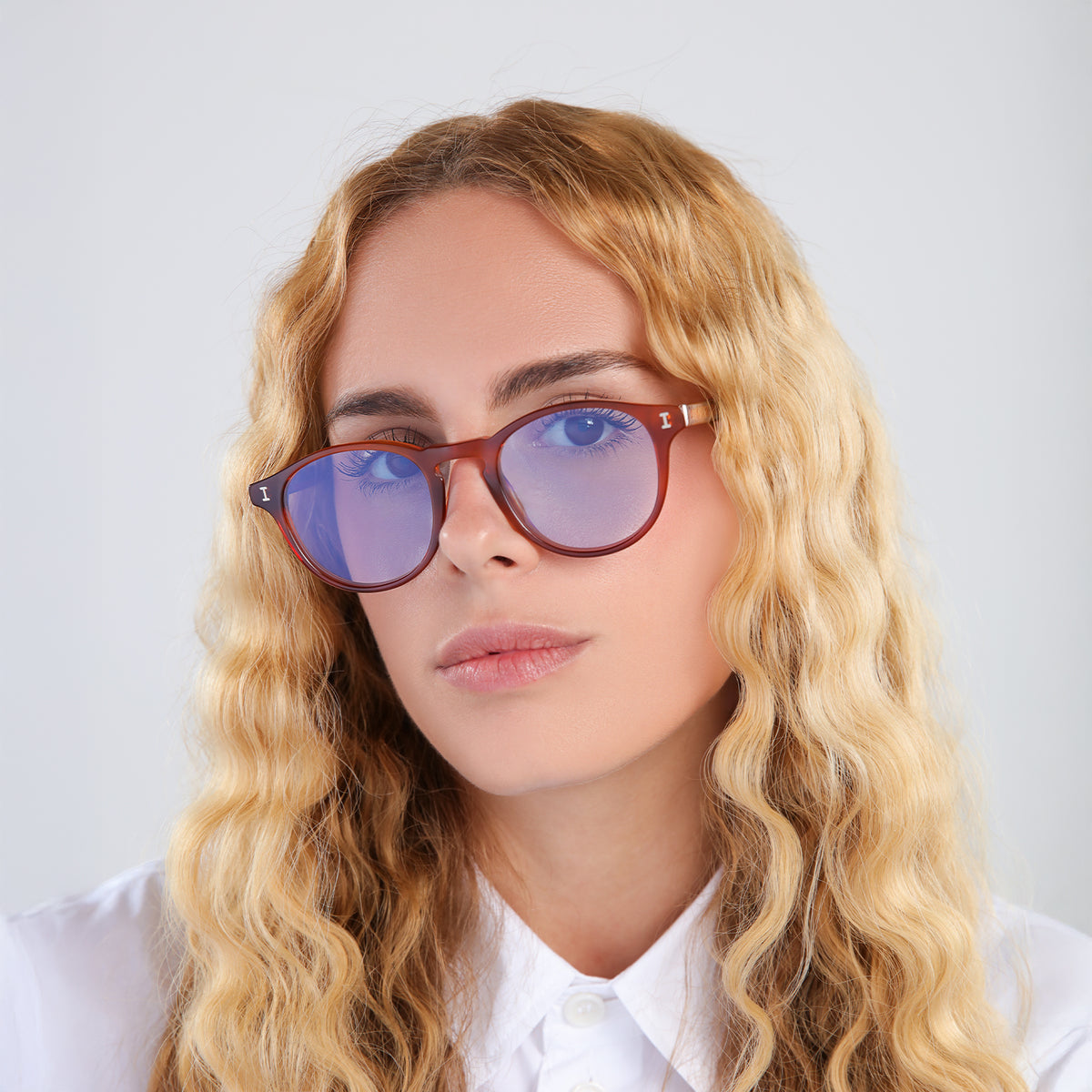 Woman wearing Lawrence Sunglasses in Red Havana with Pale Blue Flat See Through lenses, side profile, Model with blonde, wavy hair