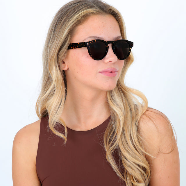 Blonde model with loose curls wearing Leonard Sunglasses Flame with Grey