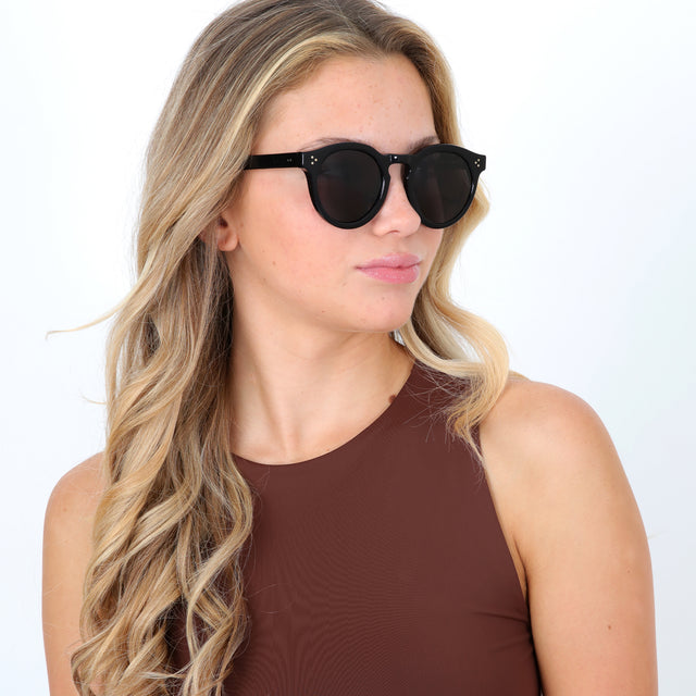 Blonde model with curls wearing Leonard II E Sunglasses Black Grey