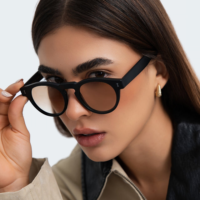 Close up of woman in a trench coat wearing Leonard Sunglasses Black with Taupe Gradient