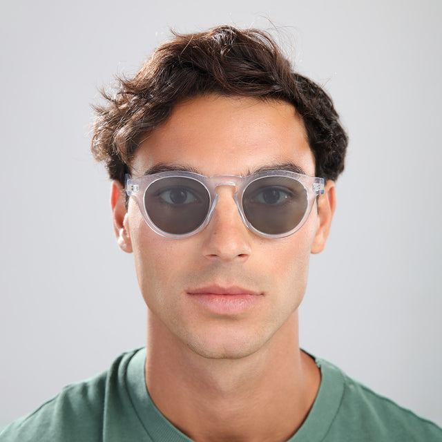 Man with brown hair in a green tee wearing Leonard Sunglasses Clear with Olive